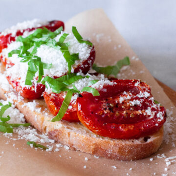 Roasted tomatoes on toast with parmesan and basil.
