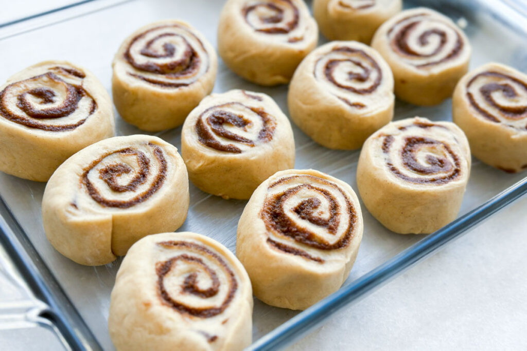 Unbaked cinnamon rolls in a pan.